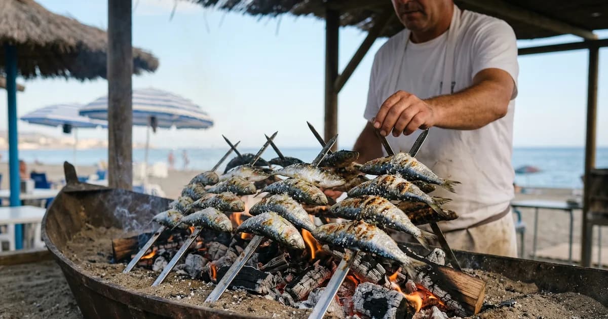 Espetos de sardinas grilling over open fire on Malaga beach chiringuito