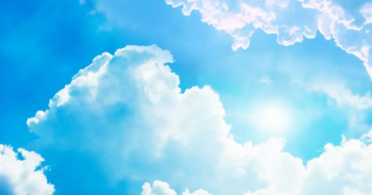 Bright sunny sky with fluffy white clouds and shining sun, depicting ideal Malaga weather in April with highs around 20-22°C.