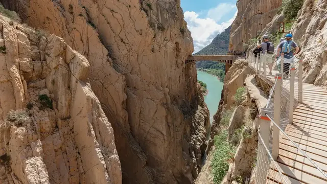 Walkers on the Caminito del Rey boardwalk bolted to a sheer limestone cliff above the Guadalhorce gorge