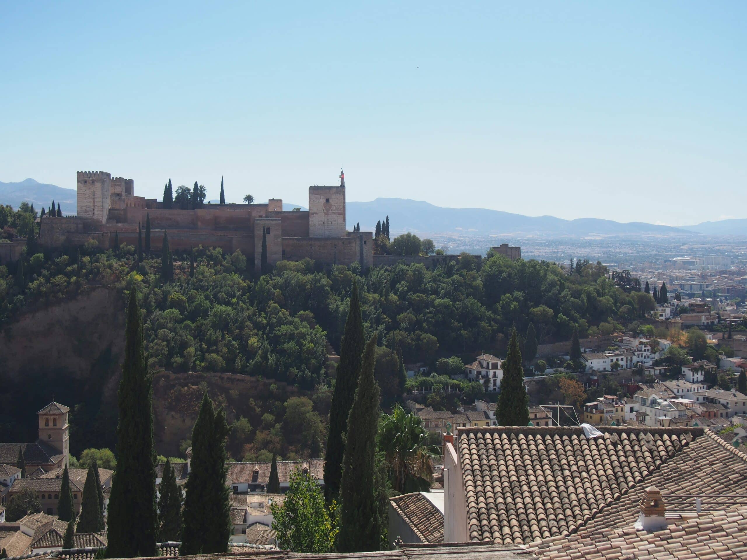 View of Alhambra Palace and grey rooftops of Granada, Spain, from above